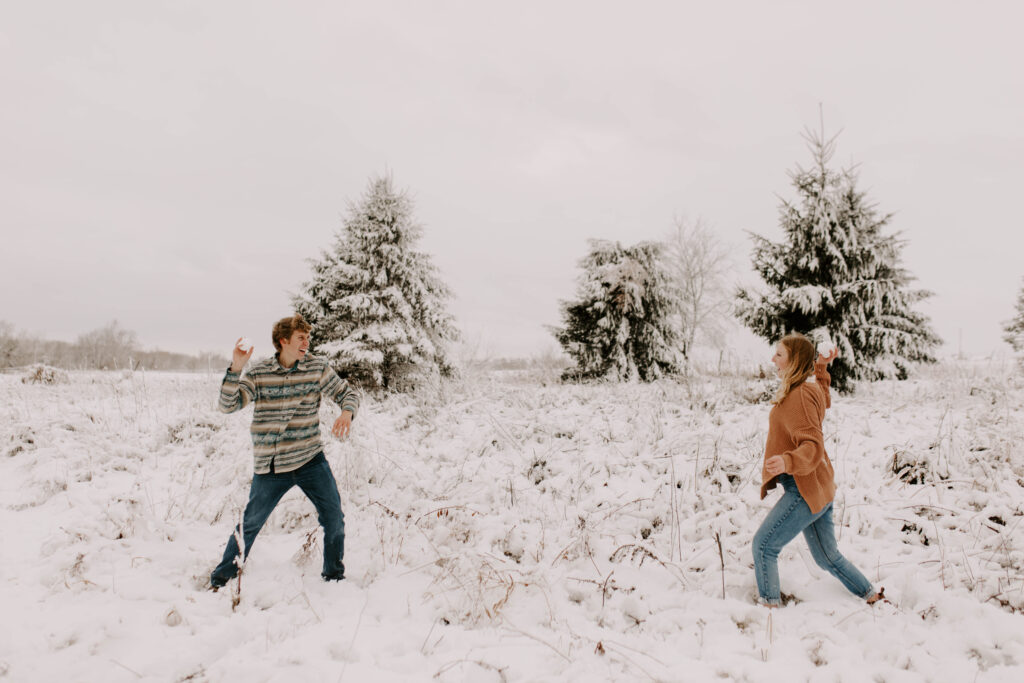 Iowa engagement session in the winter, couple has a snowball fight