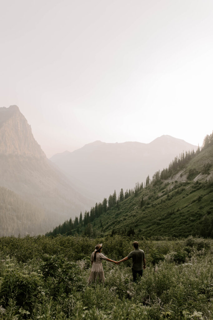 Glacier National Park Big Bend Couple holding hands and walking into sunset