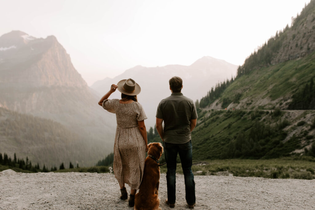 Glacier National Park Big Bend Engagement Photos, Couple looks off into distance with dog