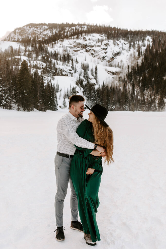 couple smiles at each other during engagement photos in Colorado 