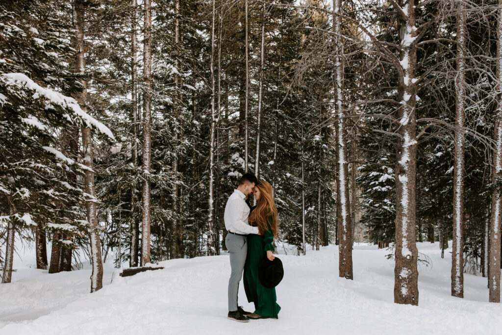 couple stands in trees by bear lake in Colorado 