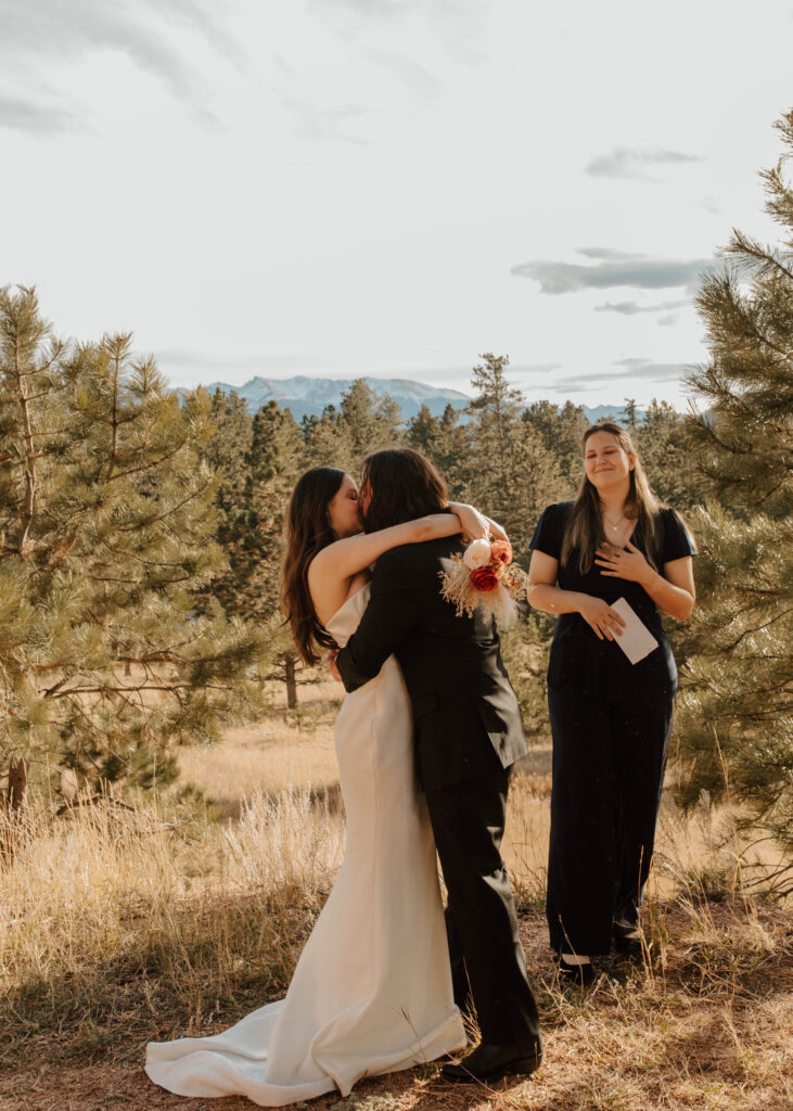 bride and groom kiss at elopement ceremony, with the mountains in the background