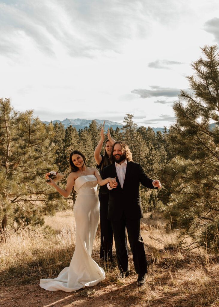 bride and groom cheer after eloping in the mountains