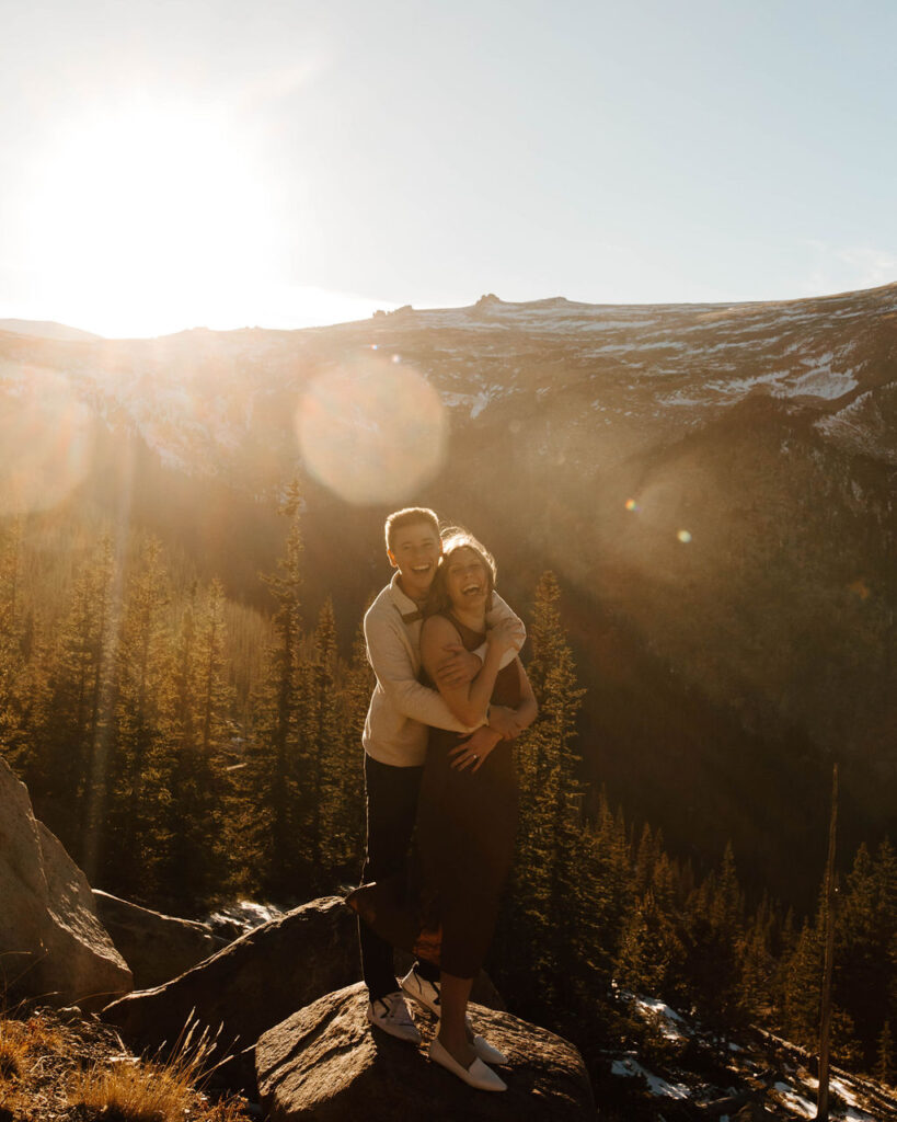 couple laughs on top of mountain