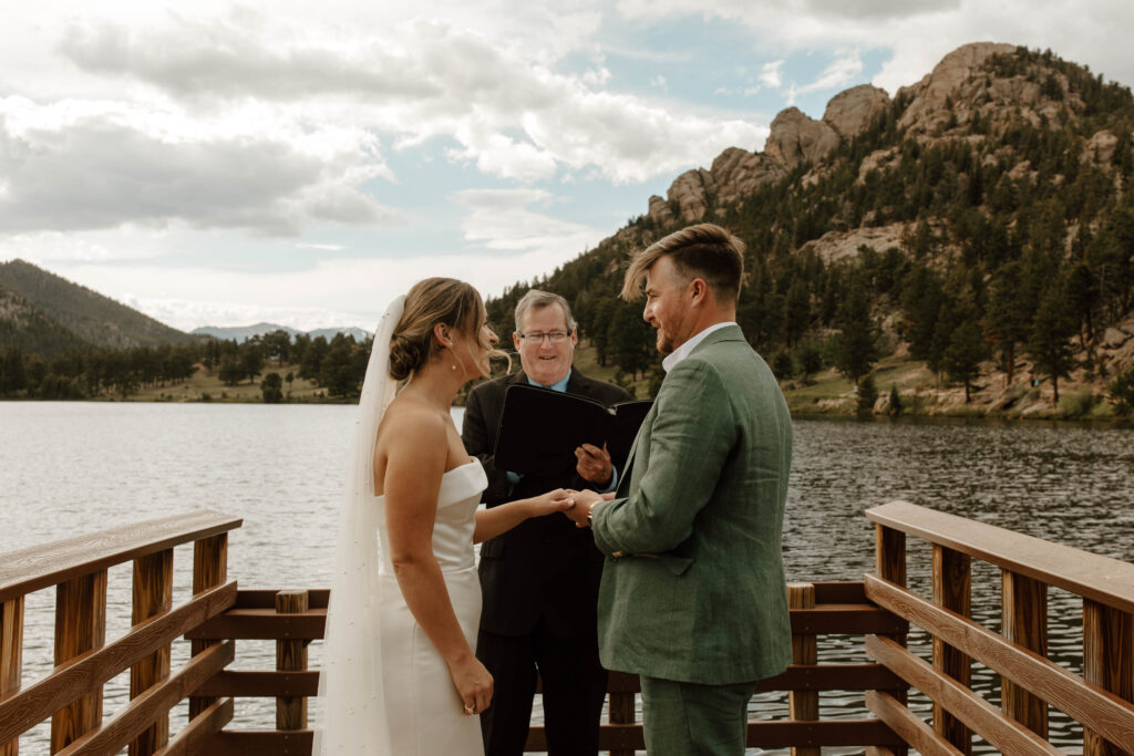 bride and groom exchange rings in elopement ceremony in the mountains