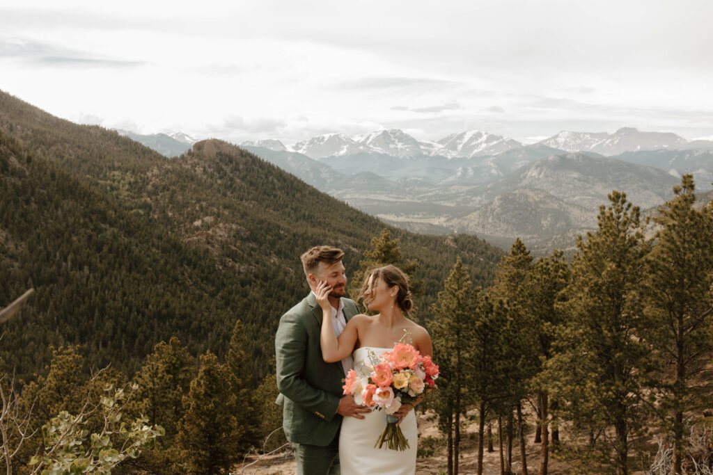 bride and groom pose in front of lily mountains rmnp
