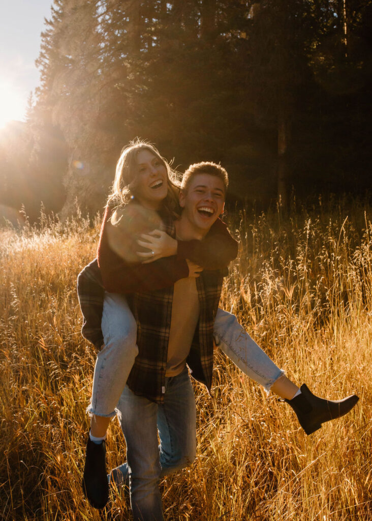 piggy back ride pose in the mountains during engagement photos