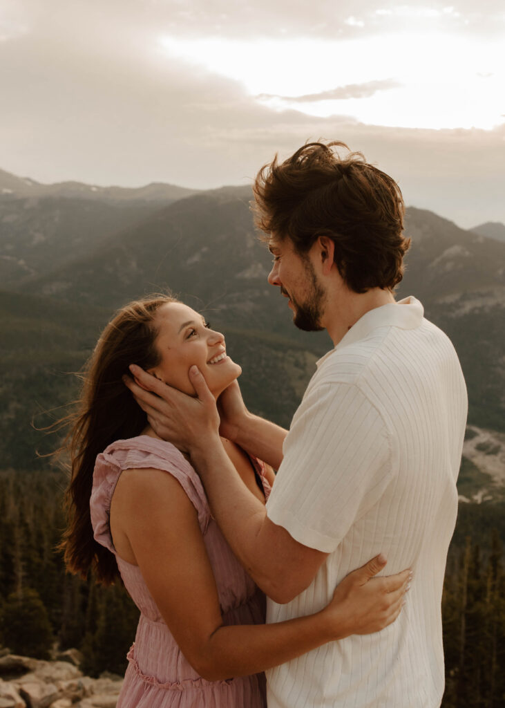 couple gazes at each other in front of the mountains 