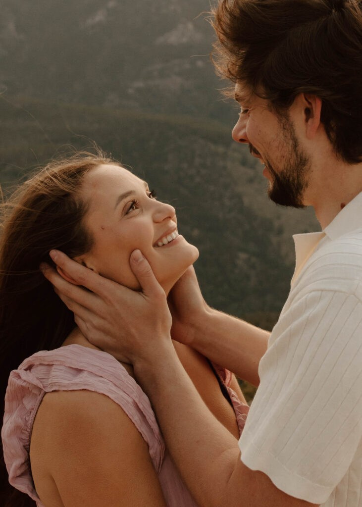 couple gazes at each other in front of the mountains 