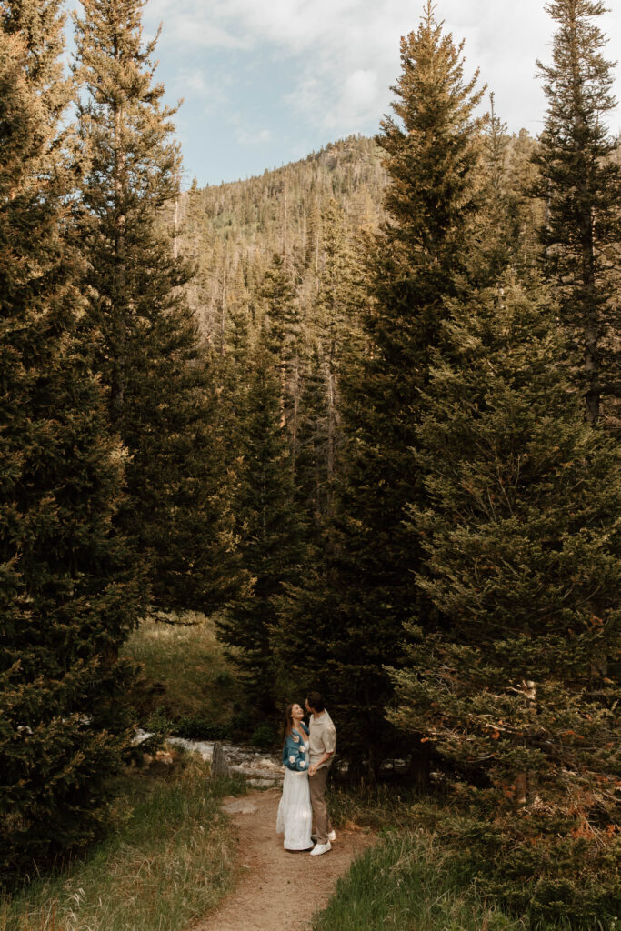 couple dances in the trees in between mountains