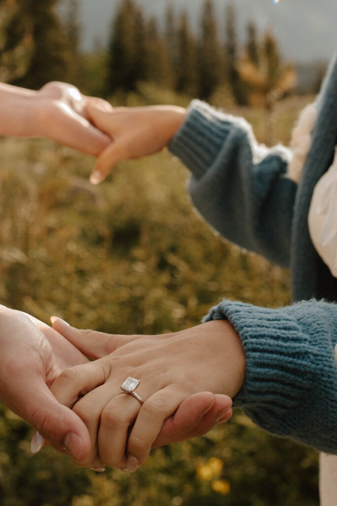 engagement ring photo as couple holds hands