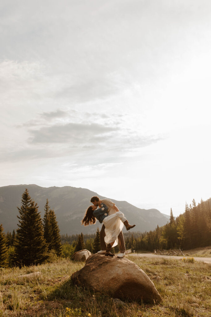 couple dips and kisses in the mountains