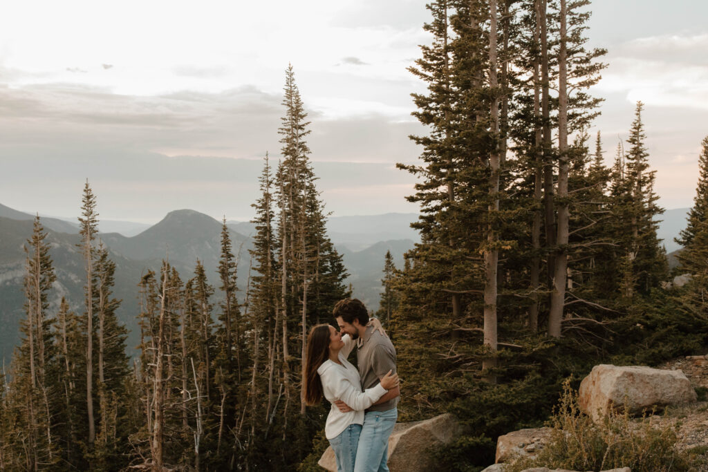 couple hugs on top of mountain
