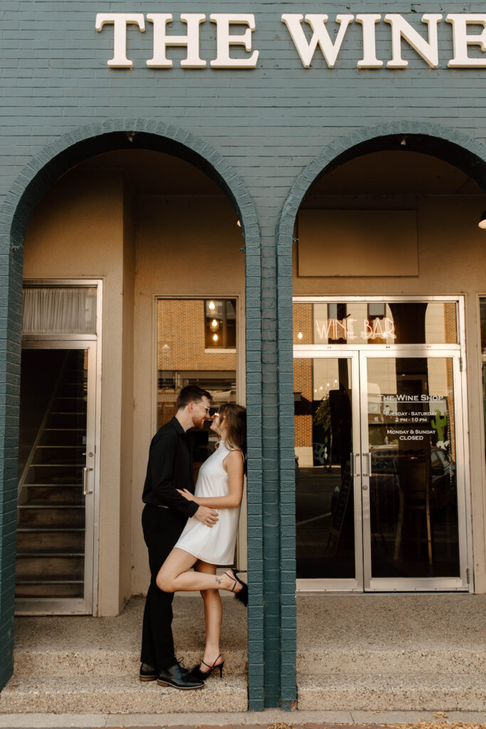 couple kisses during downtown engagement photos