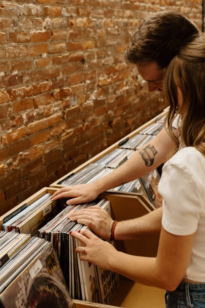 couple sifts through records on record shop date