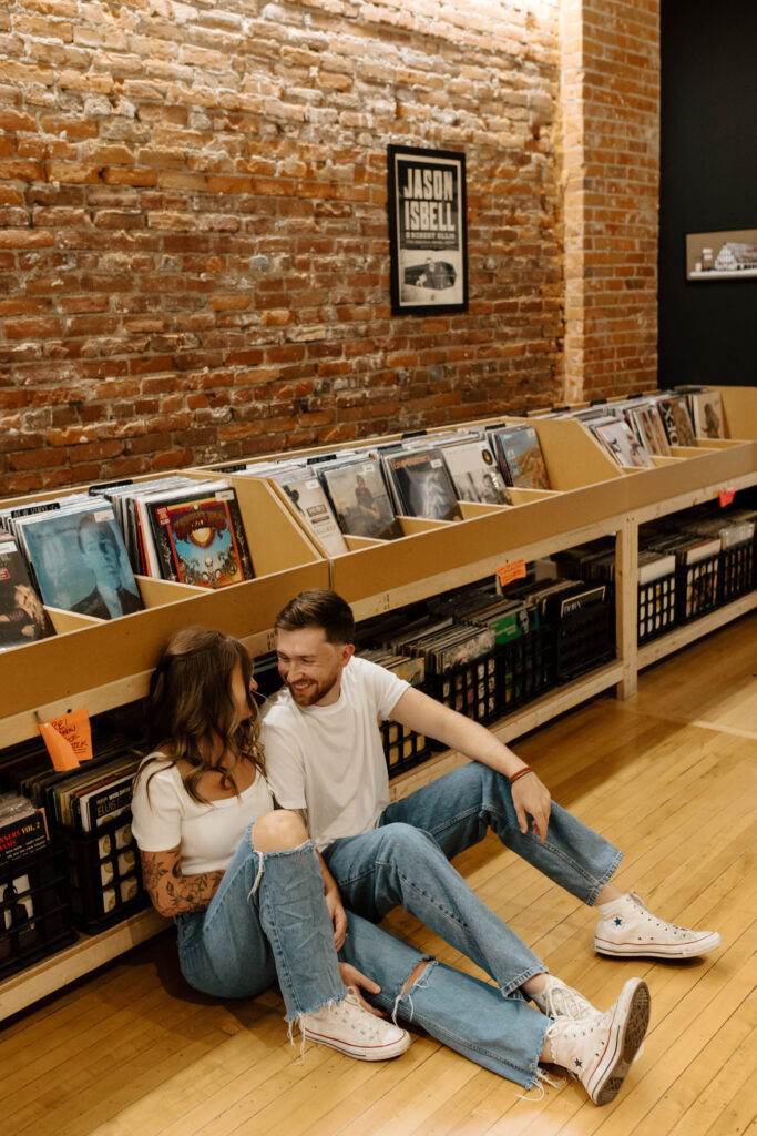 couple sits on floor of record store