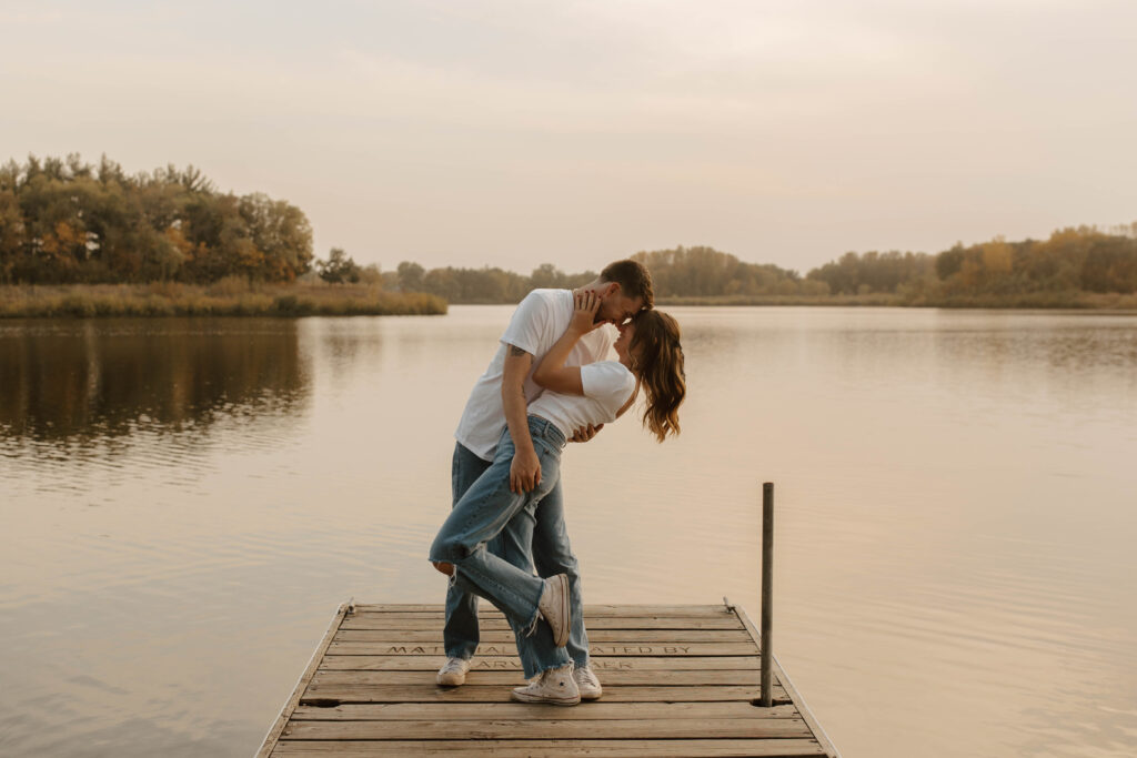 couple dips and kisses on lake