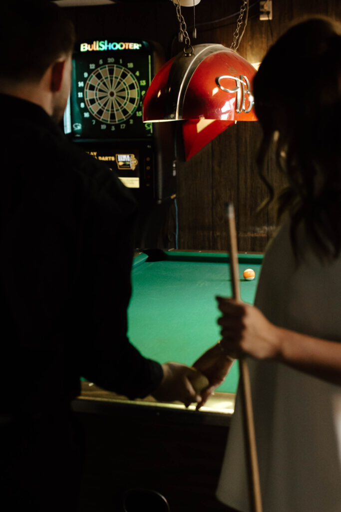 couple stands in front of pool table