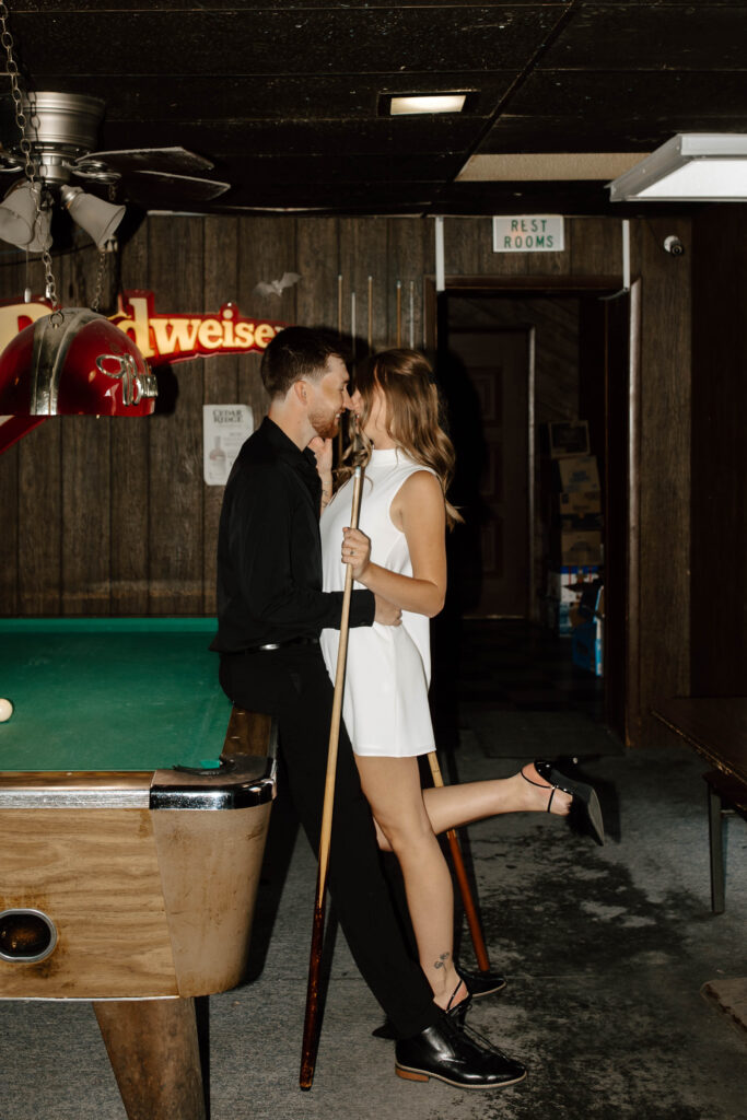 couple kisses at pool table on date