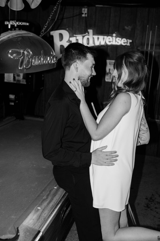 black and white photo of couple at the pool table