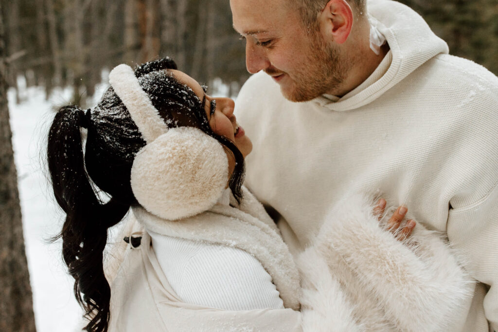 close up winter engagement photos in the snow, faces covered in snowflakes