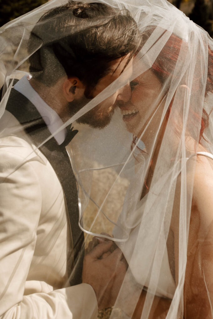 couple laughs under the veil together