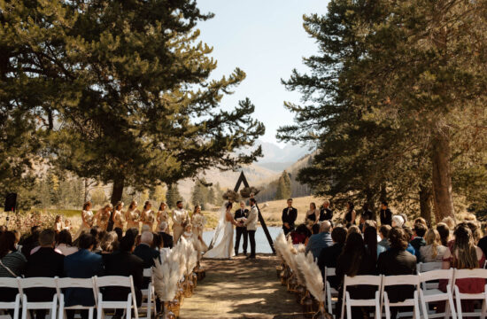 bride and groom stand at vail wedding island in colorado on a pond