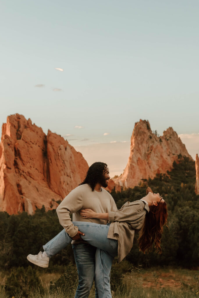 couple dips during engagement photos at garden of the gods