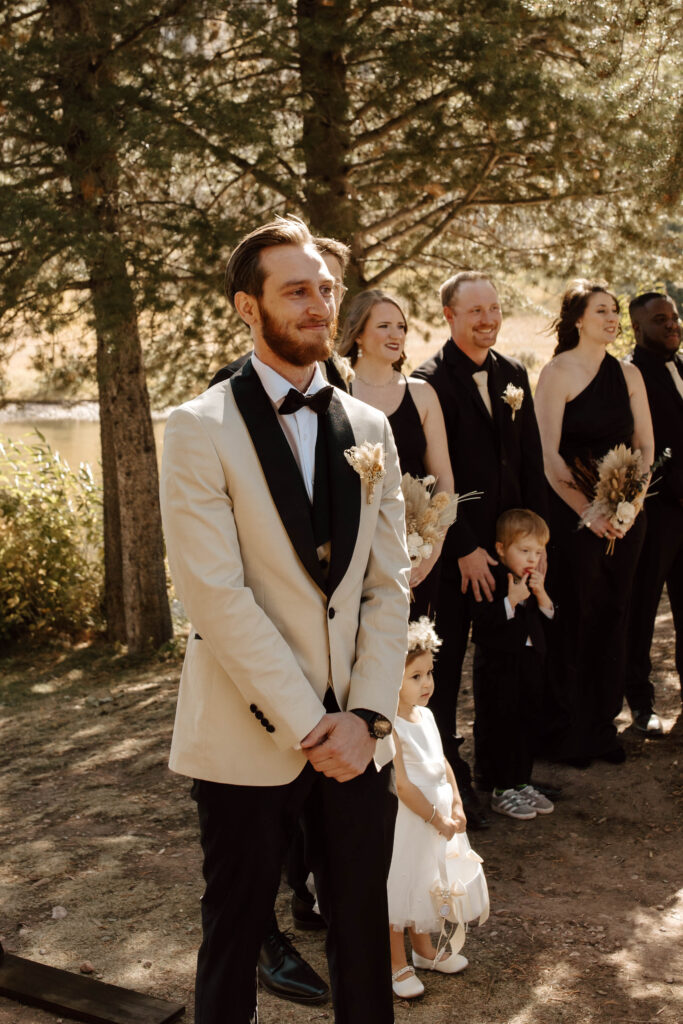 groom watches bride come down the aisle on wedding island in vail colorado