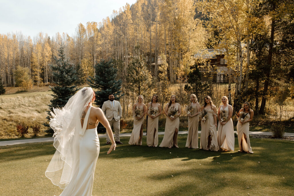 bride has first look with bridesmaids during fall mountain wedding day