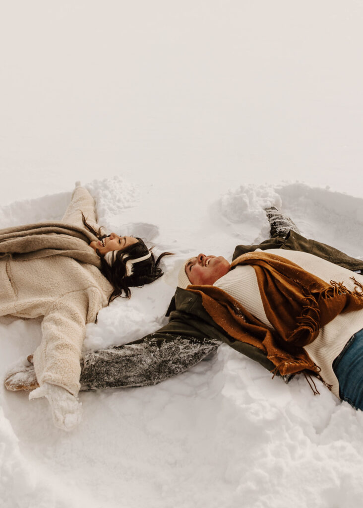 making snow angels during engagement session