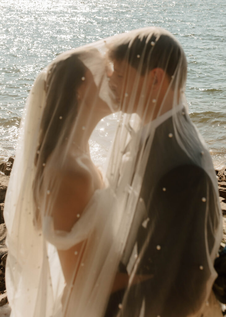 couple kisses under the bridal veil