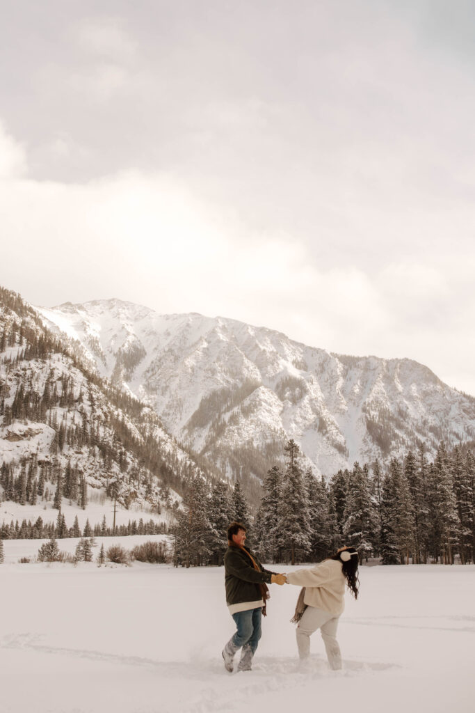 dancing on a frozen lake in colorado together in cozy clothes