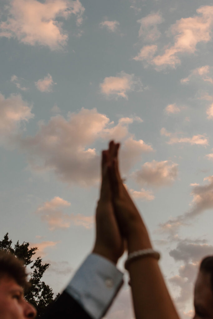 bride and groom's hands with the sunset